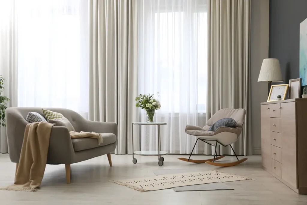 Layered sheers and drapery on floor-to-ceiling windows balance light control and privacy in this living room.